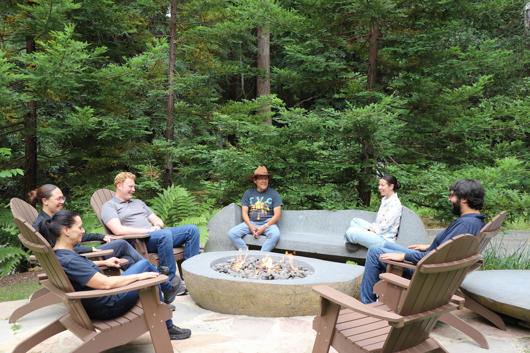 A circle gathered at the fire in the redwoods at 1440 Multiversity