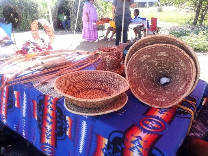 Woven baskets displayed on a Pendleton blanket at a trade gathering