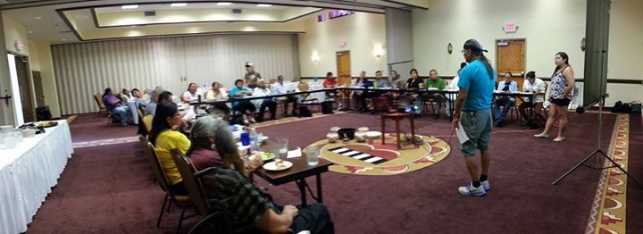 Elders and community members seated in a large circle at a gathering
