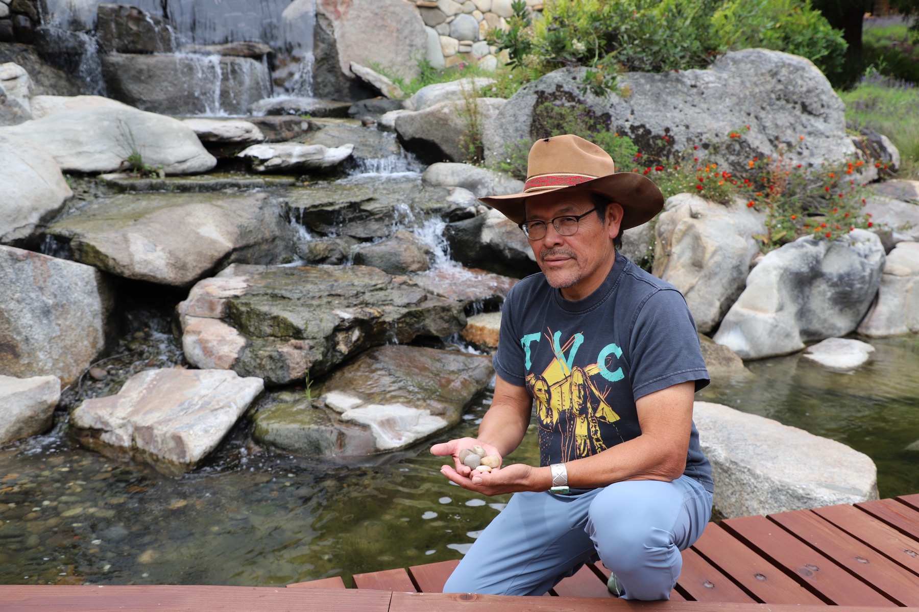 Tony beside the creek, stones in hand